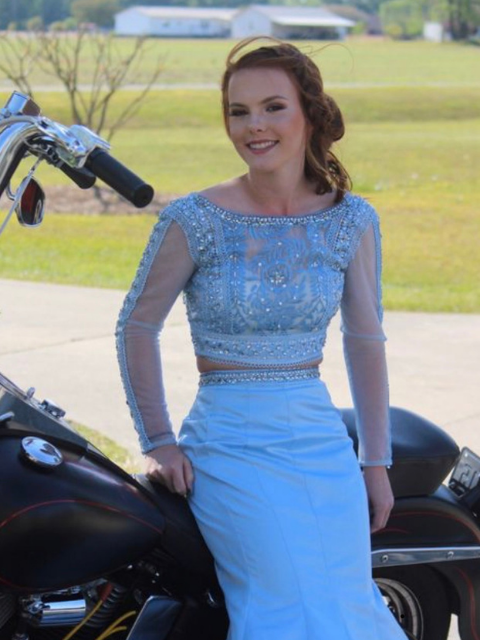 A model in a blue prom dress near the motorcycle