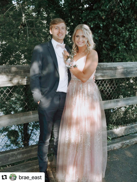 Photo of the couple in a rosy prom gown and suit